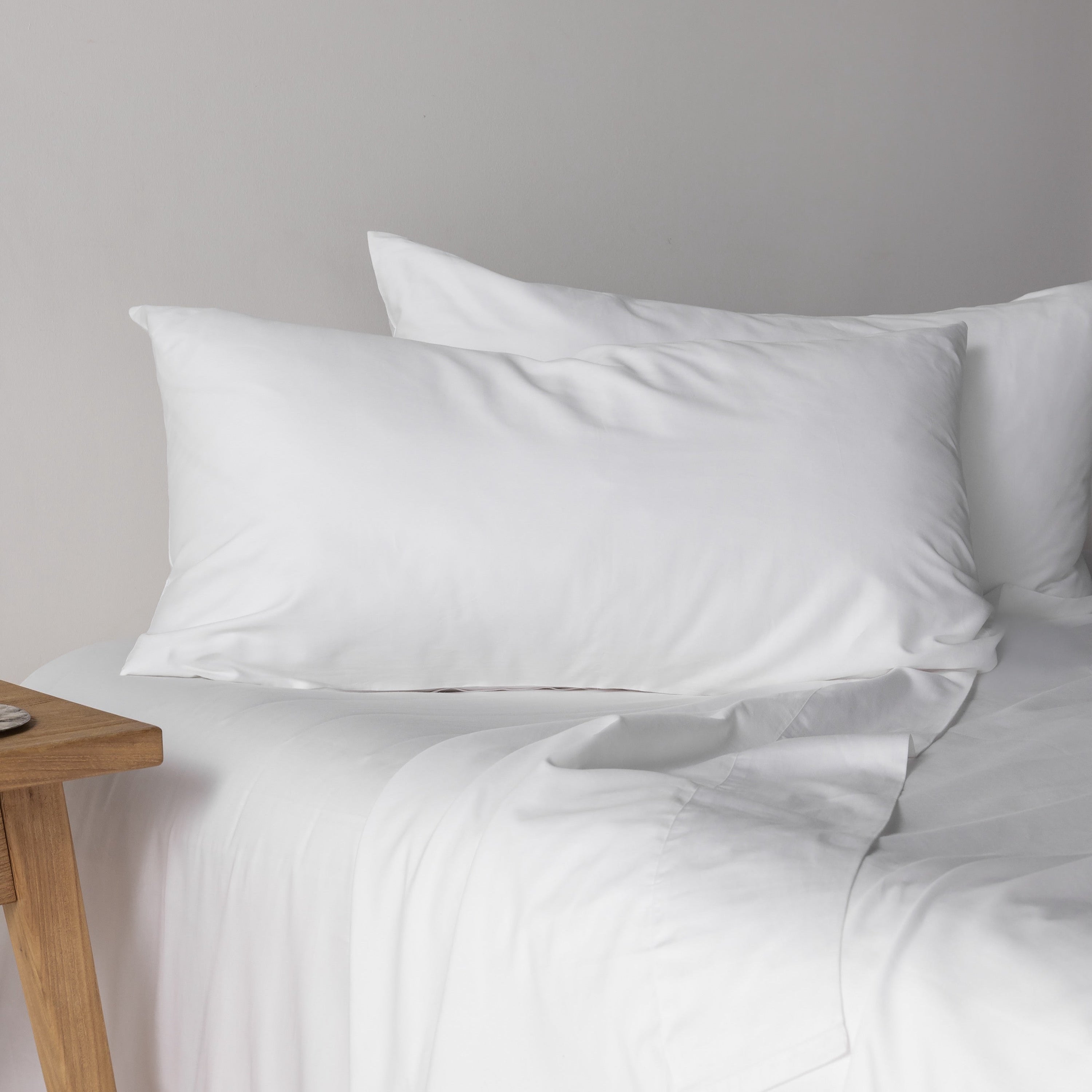 Sierra Dreams organic sateen sheet set in Snow on a made bed